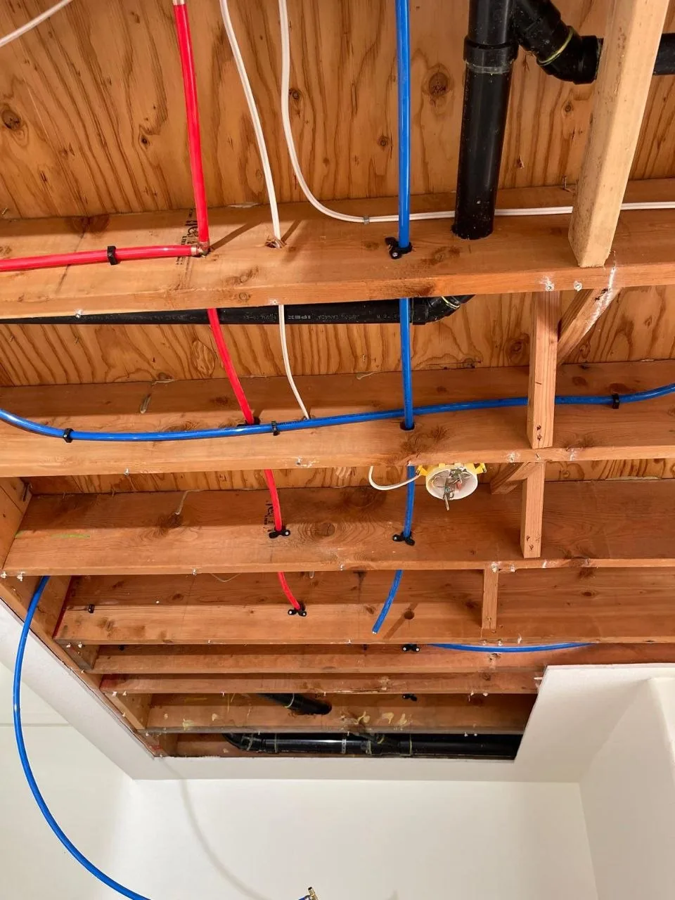 New PEX water lines installed through an exposed ceiling