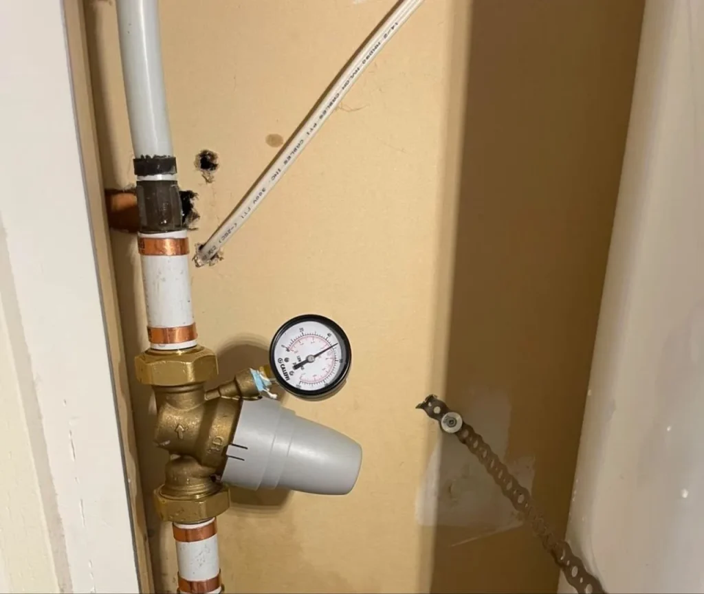 Pressure reducing valve with gauge installed in wall cavity